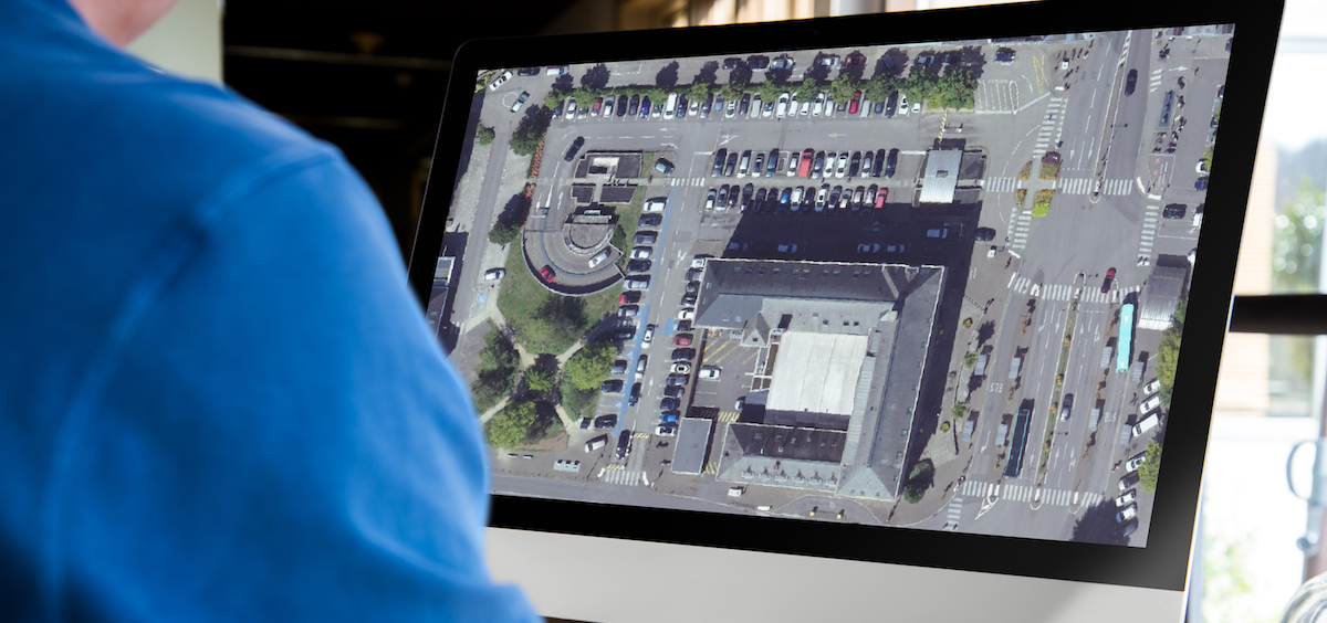Homme travaillant sur un ordinateur de type iMac et affichant un système d&#x27;information géographique